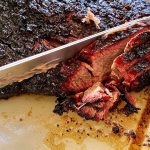 brisket being sliced with a carving knife