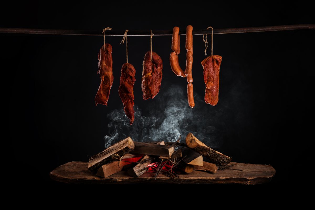 smoked meats hanging over wood fire