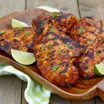 bone in chicken on platter with lime wedges